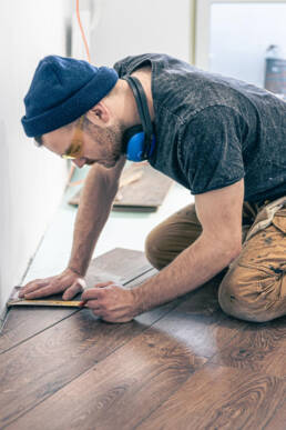 male worker puts laminate flooring floor