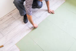 worker processing floor with bright laminated flooring boards